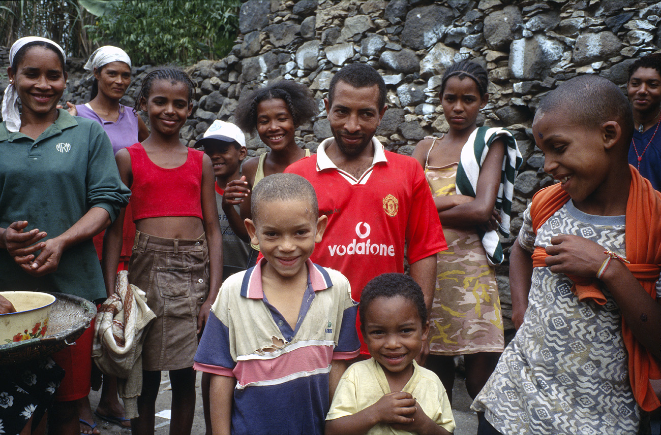 cve05_303l.jpg - Santo Antao Caibros Au Cap Vert, on fait souvent la fête. Le chef de famille m'a tendu sa bouteille de grogue et le verre, avec un sourire chaleureux et après s'être servi une bonne rasade pour me montrer que c'est du bon !