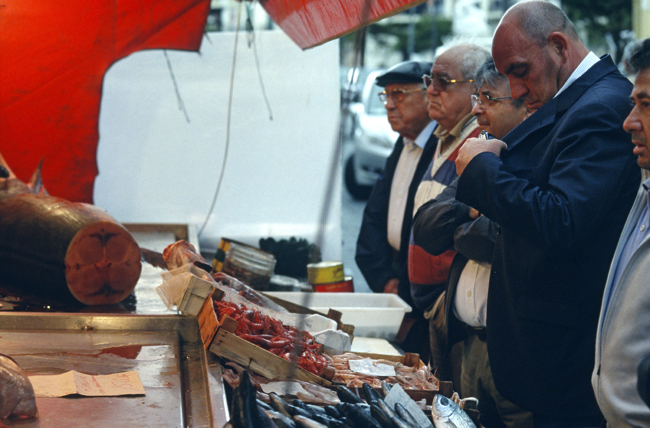 eol06_005.jpg - Italie, Îles Éoliennes - Milazzo alignement de siciliens devant le marché aux poissons : on se prépare à mettre la main à son portefeuille Fuji Provia 400 F