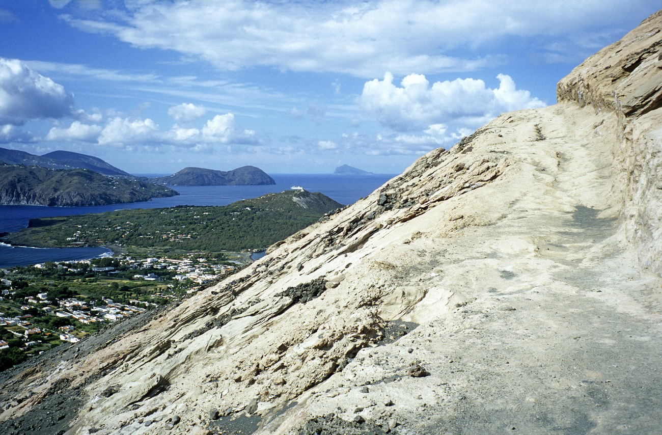 eol06_091l.jpg - Italie, îles Eoliennes Vulcano le sentier entre dans une zone modelée par le volcanisme. En face, Lipari et tout au fond Panarea Fuji Velvia 100 F