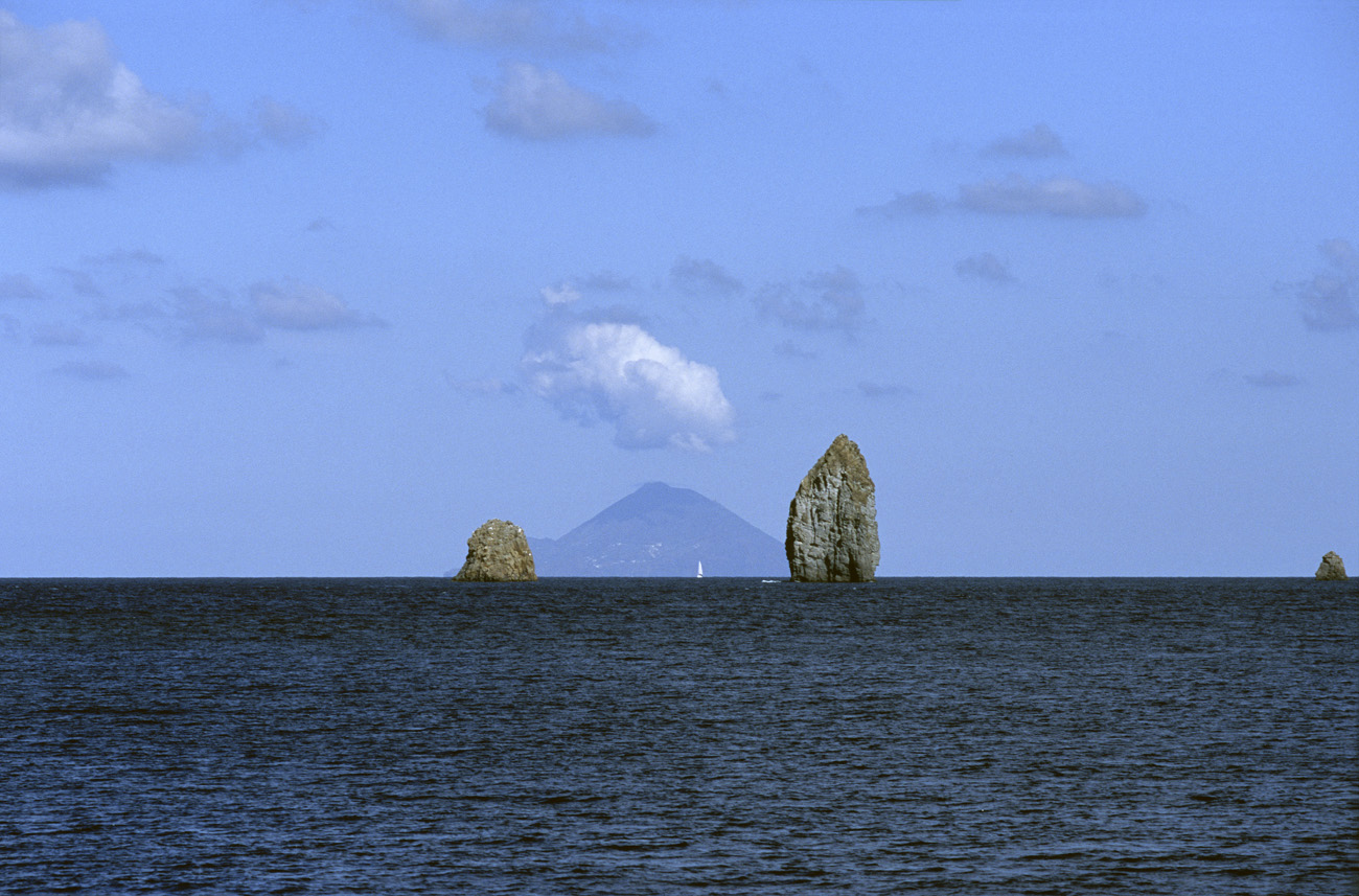 eol06_141.jpg - Italie, îles Eoliennes Lipari les faraglioni, dents de basalte, encadrent Filicudi Fuji Velvia 100 F