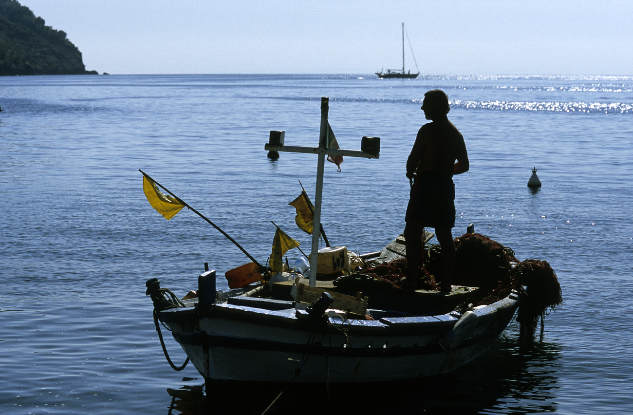 eol06_226.jpg - Italie, îles Eoliennes Lipari silhouette d'un pêcheur qui vient de ravauder ses filets Fuji Velvia 100 F