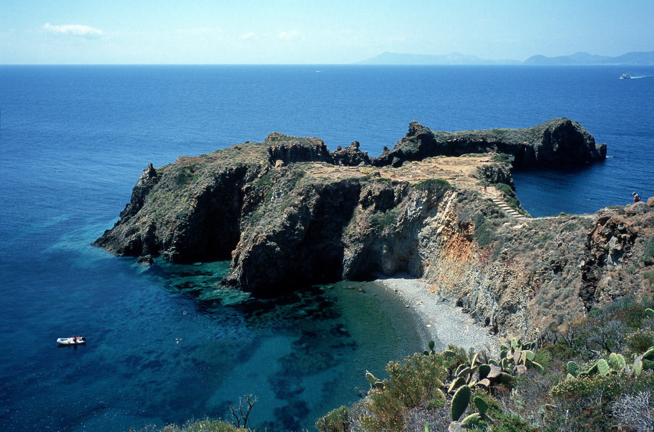 eol06_353la.jpg - Italie, îles Eoliennes Panarea un site néolithique défendu naturellement par les falaises, dans un cadre étonnant face à Vulcano et Lipari que l'on distingue au loin Fuji Velvia 100F