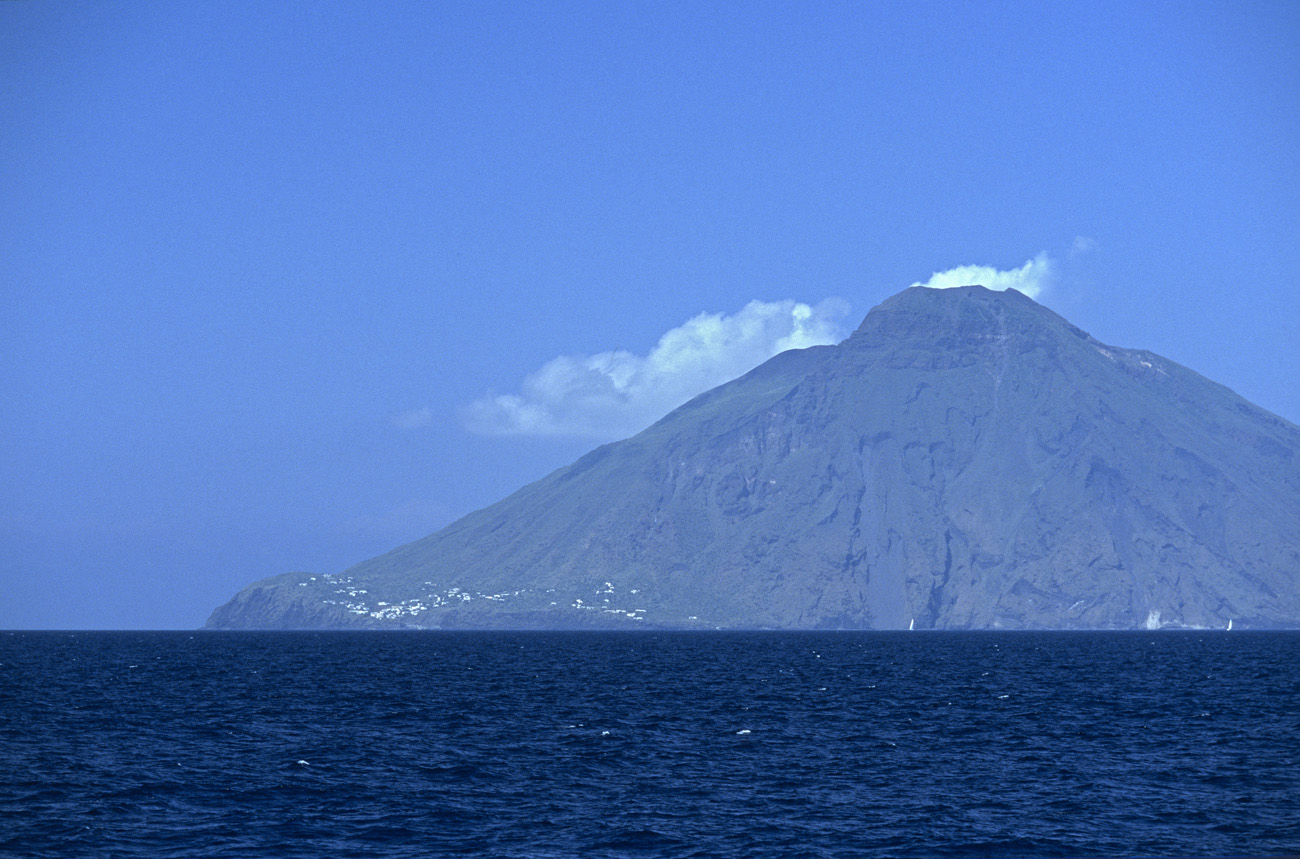 eol06_378.jpg - Italie, îles Eoliennes Stromboli le Stromboli empanaché par son activité volcanique permanente se rapproche lentement à l'allure de la goélette de huit à dix noeuds Fuji Velvia 100 F