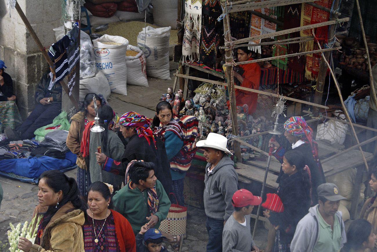 gua06_0090.jpg - Chichicastenango des prêtres du culte maya se fraient un chemin dans le marché pour parvenir à l'église..