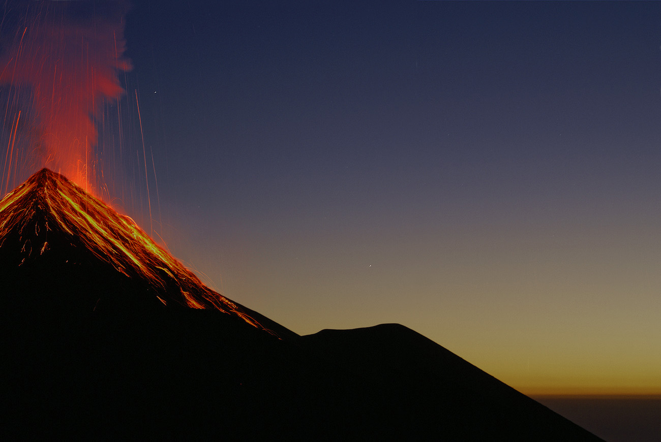 gua06_0638b.jpg - volcan Fuego face aux tentes plantées sur l'Acatenango à 3500m, un spectacle extraordinaire : l'éruption principale est nettement au sud-ouest, mais les retombées de magma fluide ruissellent ensuite sur le cône volcanique avant de s'éteindre, le tout en moins de 30 secondes