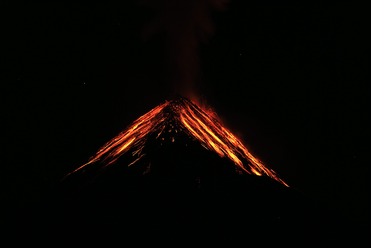 gua06_0644.jpg - volcan Fuego face aux tentes plantées sur l'Acatenango à 3500m, un spectacle extraordinaire : l'éruption principale est nettement au sud-ouest, mais les retombées de magma fluide ruissellent ensuite sur le cône volcanique avant de s'éteindre, le tout en moins de 30 secondes