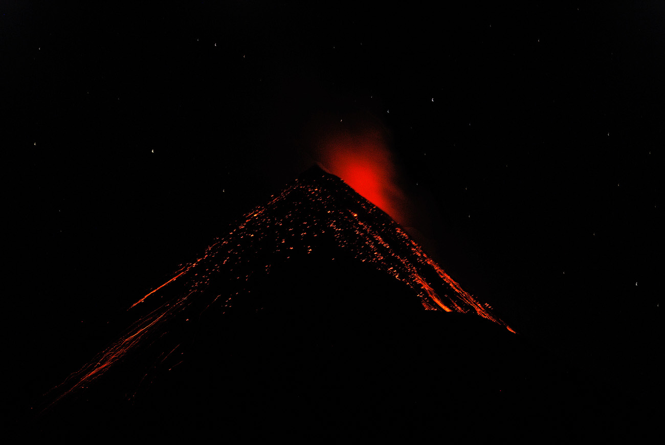 gua06_0645.jpg - volcan Fuego face aux tentes plantées sur l'Acatenango à 3500m, un spectacle extraordinaire : l'éruption principale est nettement au sud-ouest, mais les retombées de magma fluide ruissellent ensuite sur le cône volcanique avant de s'éteindre, le tout en moins de 30 secondes. Dans le ciel, on distingue les étoiles